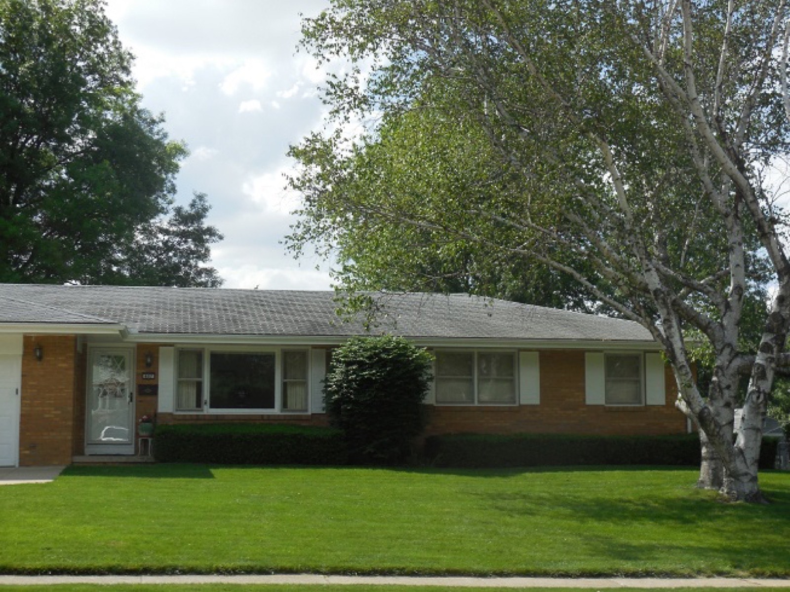 A well-kept front lawn in front of a single-story home